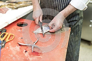 British fish monger fillets a dover sole and pulls itÃ¢â¬â¢s skin a photo